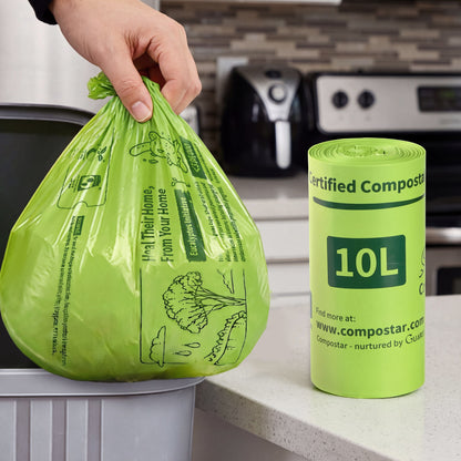 Robust 10L compostable FOGO bin liners being lifted from a small kitchen caddy