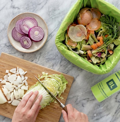 Eco-friendly 8L caddy liners being used for organic kitchen food scraps on a benchtop